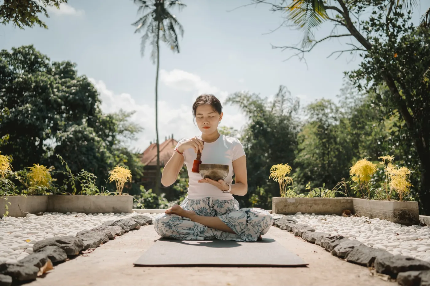 Irene Tan, founder of Inara Sanctuary, seated in meditation with a singing bowl
